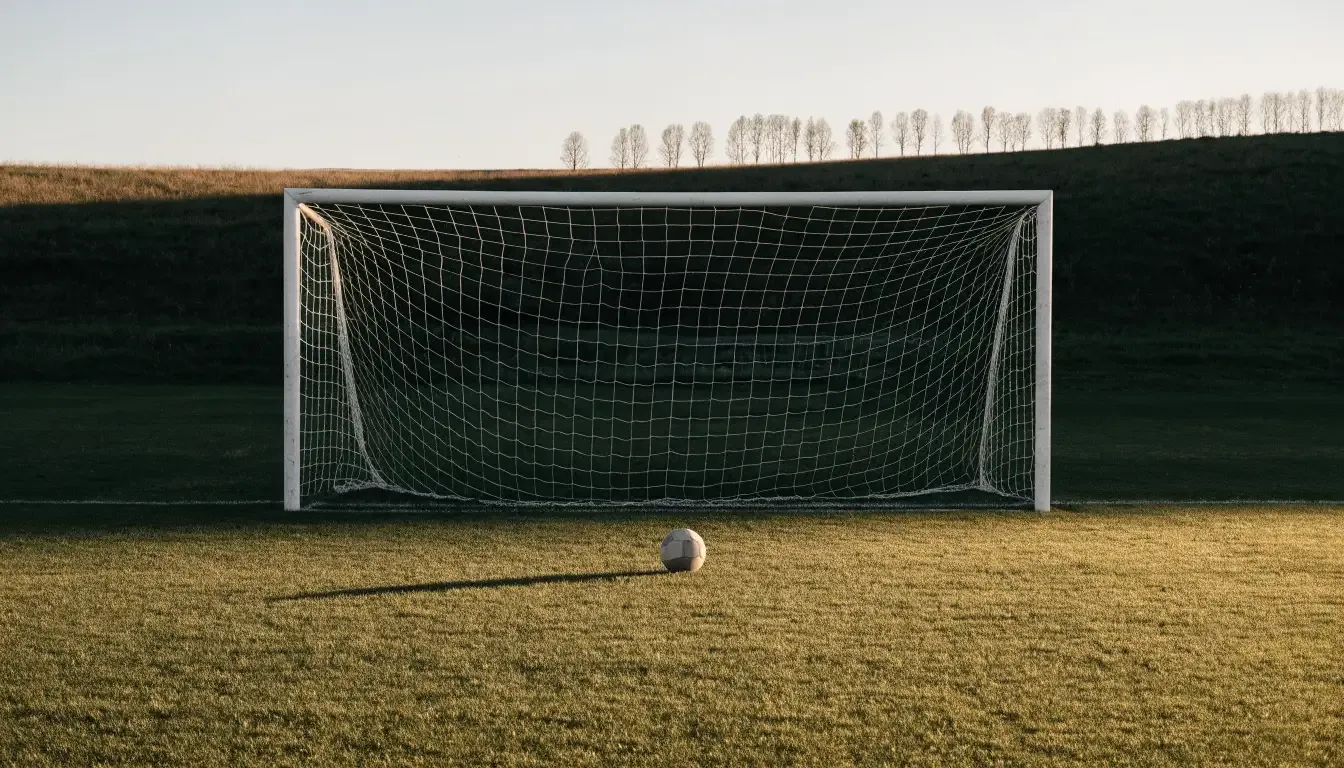 Ein Fussballtor mit locker hängendem Netz auf einem Trainingsplatz, das sich leicht im Wind bewegt.